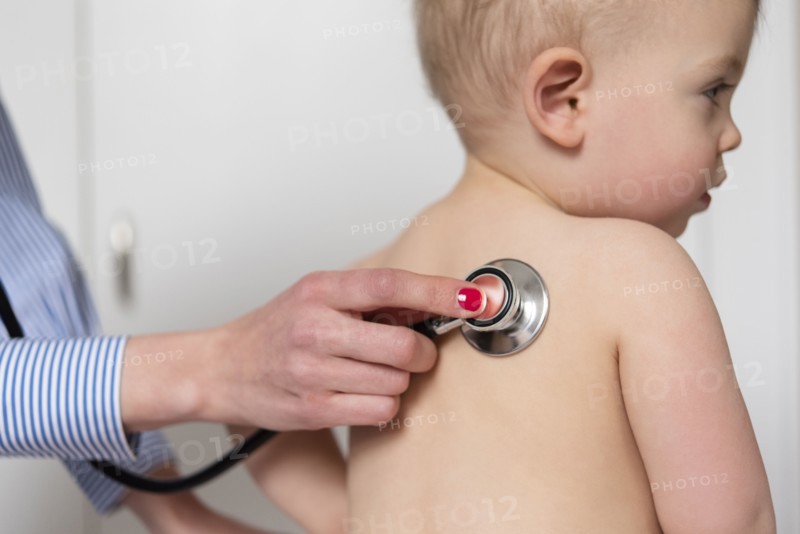 Paediatrician using stethoscope on girl