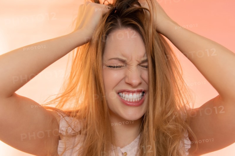 Stressed young woman with her hands in her hair