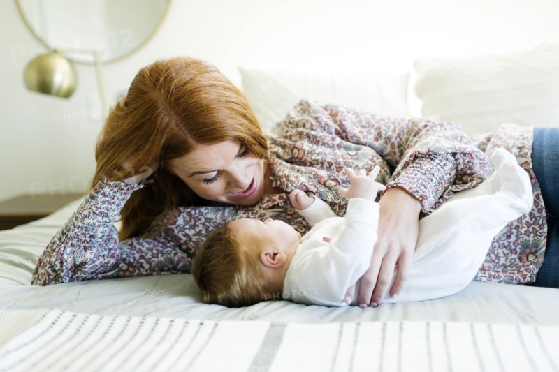 Mother lying on bed with her newborn son