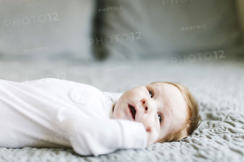 Baby boy lying on bed