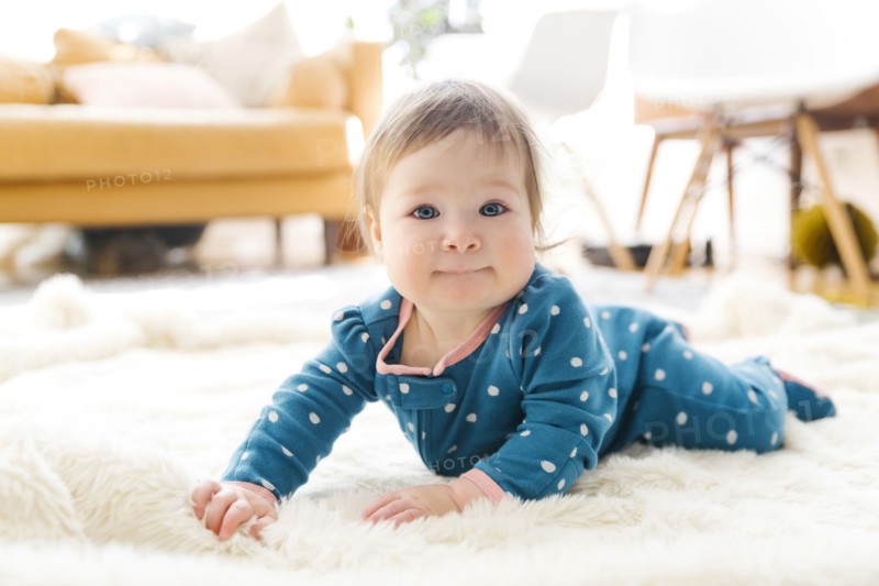 Baby girl lying on rug