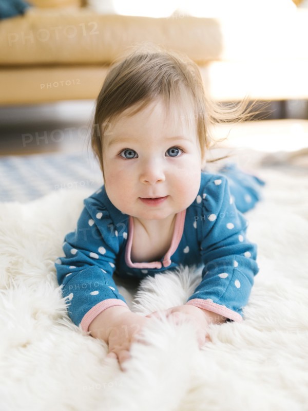 Baby girl lying on rug