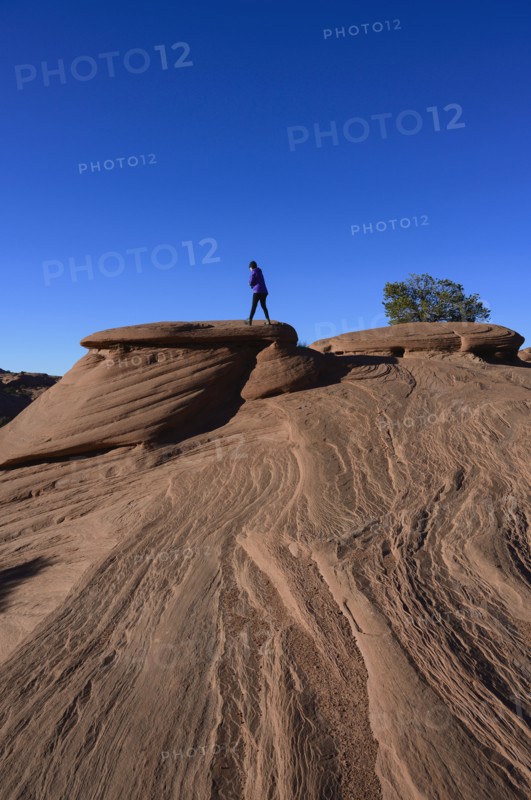 Woman walking on smooth rocks in Monument Valley, Arizona, USA