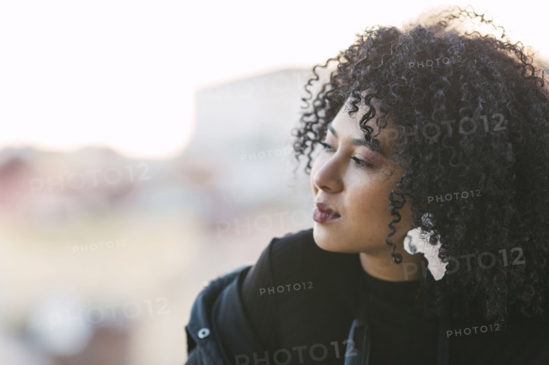 Portrait of young woman with curly black hair