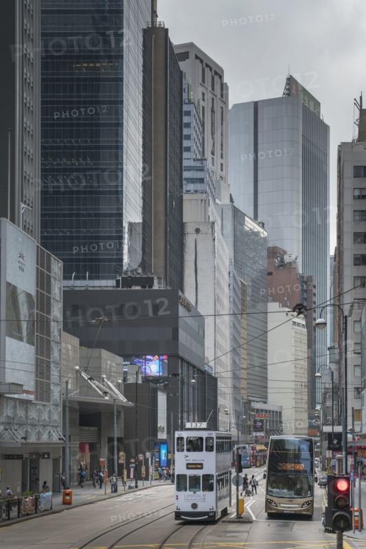Double-decker tram and bus on street in Hong Kong, China