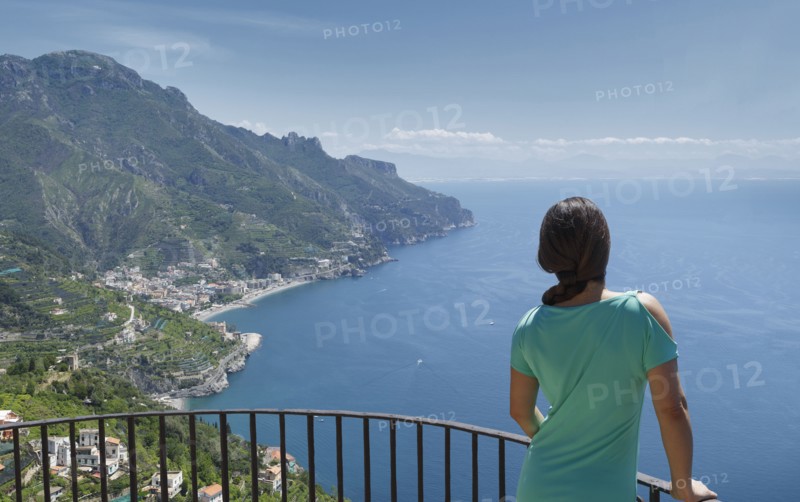 Woman leaning on railing by Amalfi Coast, Italy