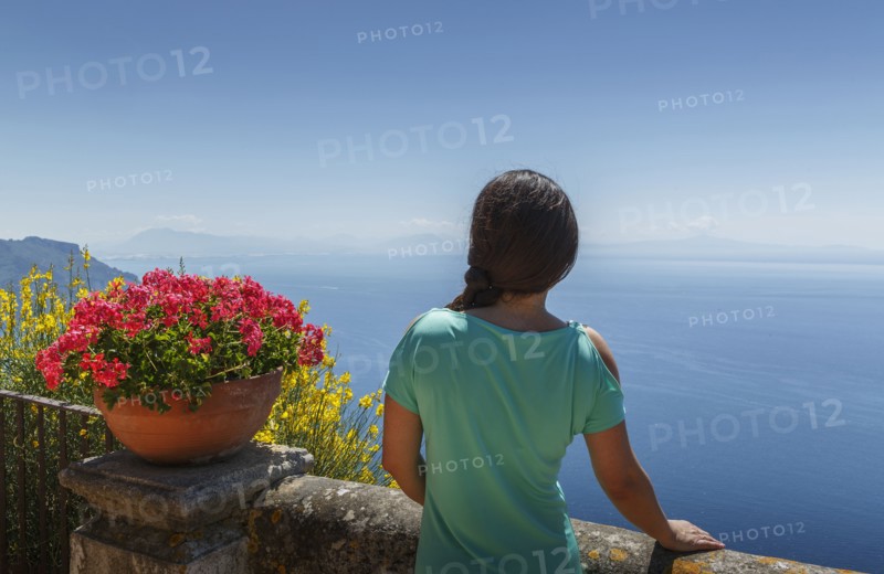 Rear view of woman by flower pot