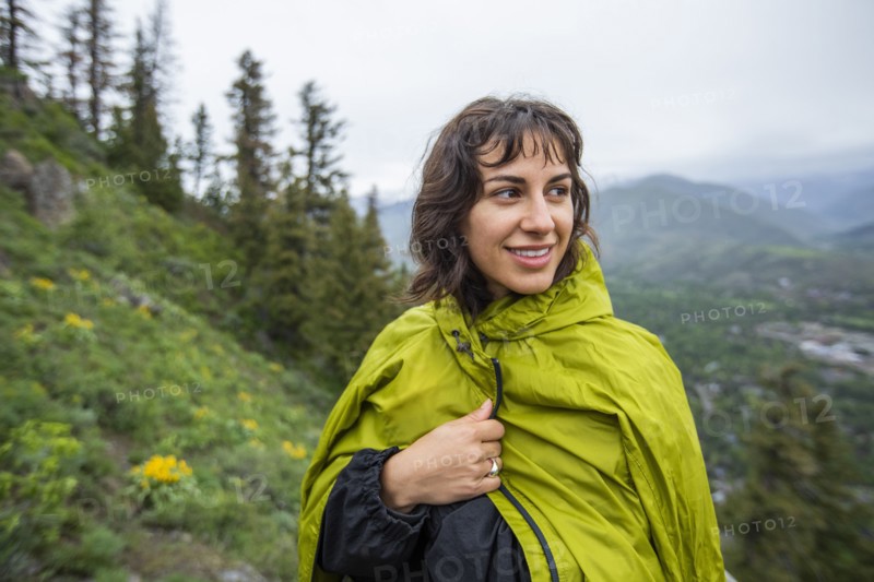 Young woman wearing green raincoat on hike