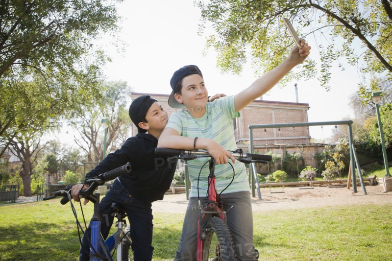 Brothers taking selfie on bicycles