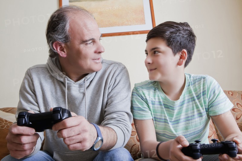 Father and teenage son playing video game