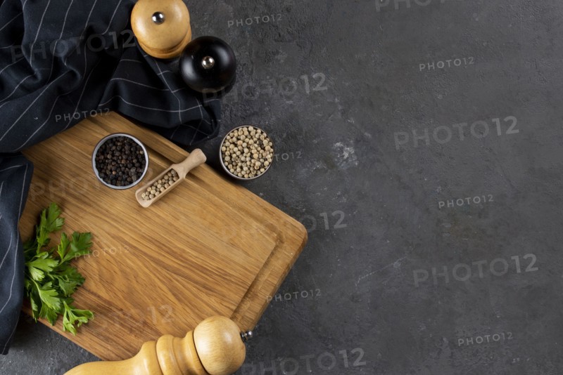 Pepper and pepper mills on cutting board