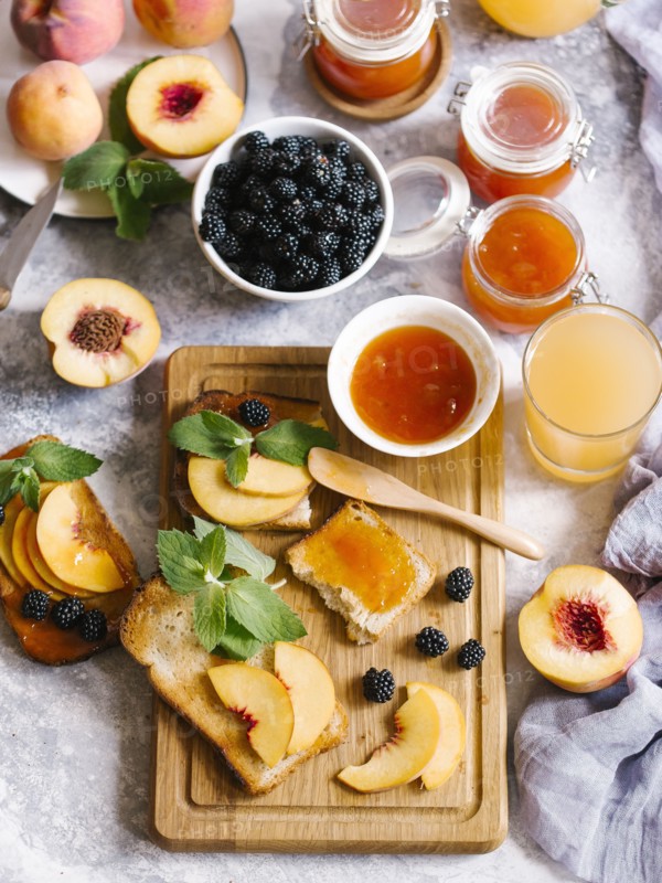 Breakfast spread with blackberries, peaches, toast and apricot jam