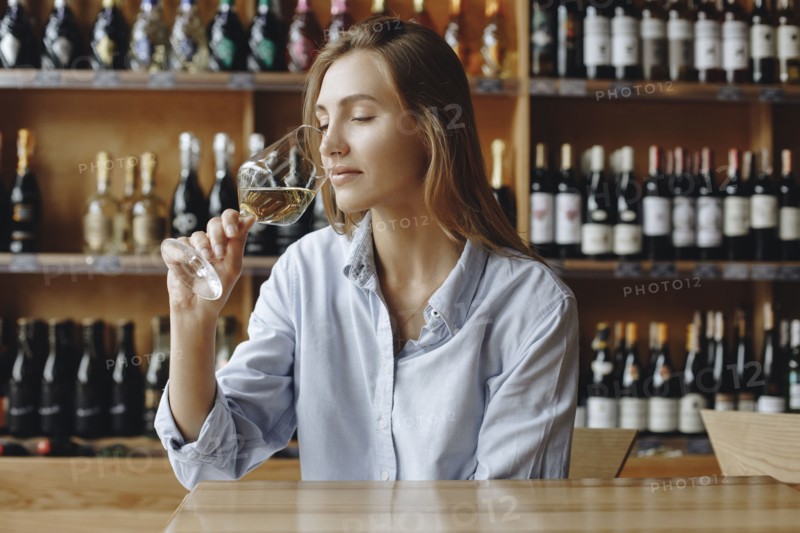 Young woman sniffing glass of white wine