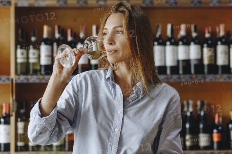 Young woman drinking glass of white wine