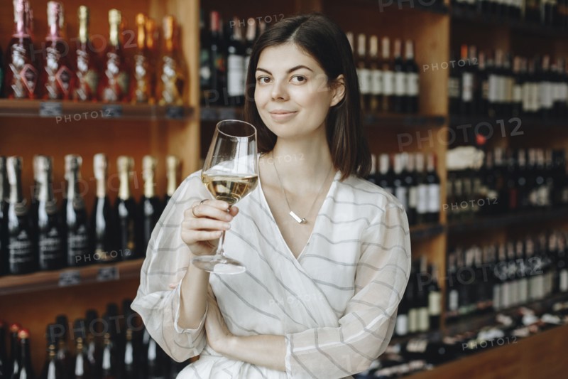Young woman holding glass of white wine
