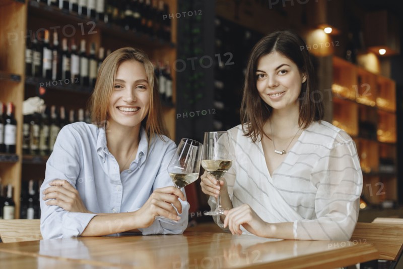 Young women toasting with glasses of white wine