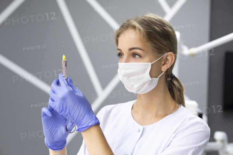 Dental assistant holding syringe