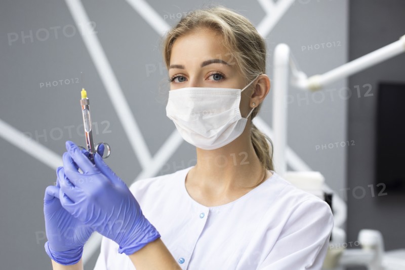 Dental assistant holding syringe