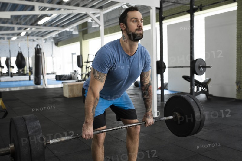 Mid adult man weight lifting in gym
