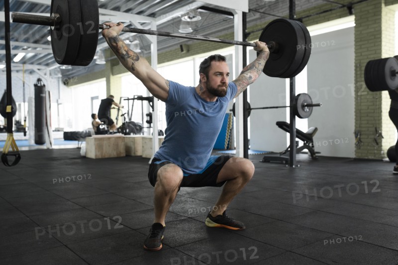Mid adult man weight lifting in gym