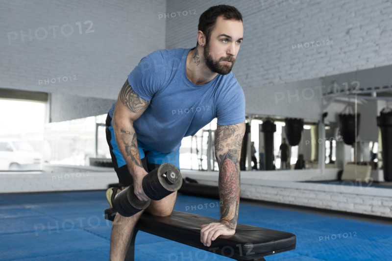 Mid adult man lifting dumbbell in gym