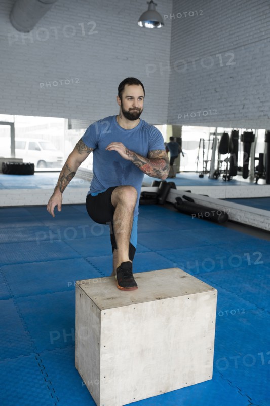 Man stepping onto box in gym