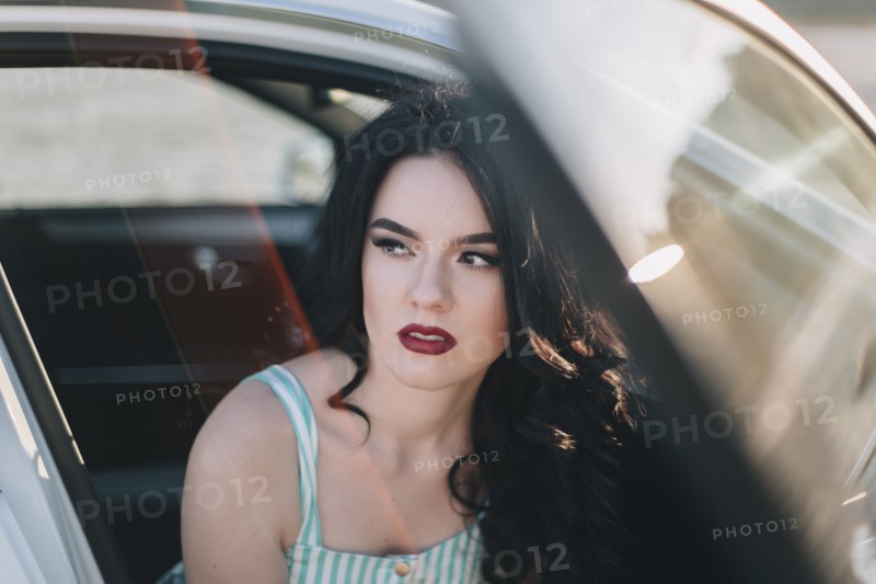 Young woman wearing red lipstick sitting in car