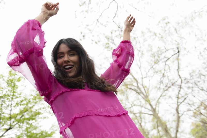 Smiling woman dancing in pink dress