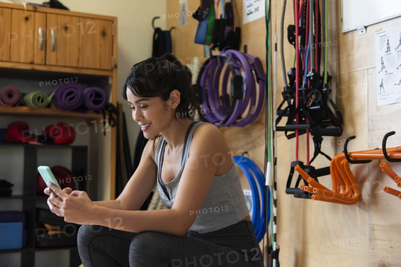 Woman using smart phone in gym