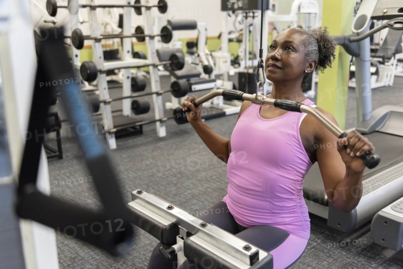 Mature woman weight training in gym