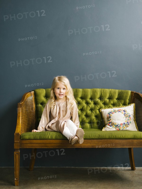 Girl sitting on green sofa