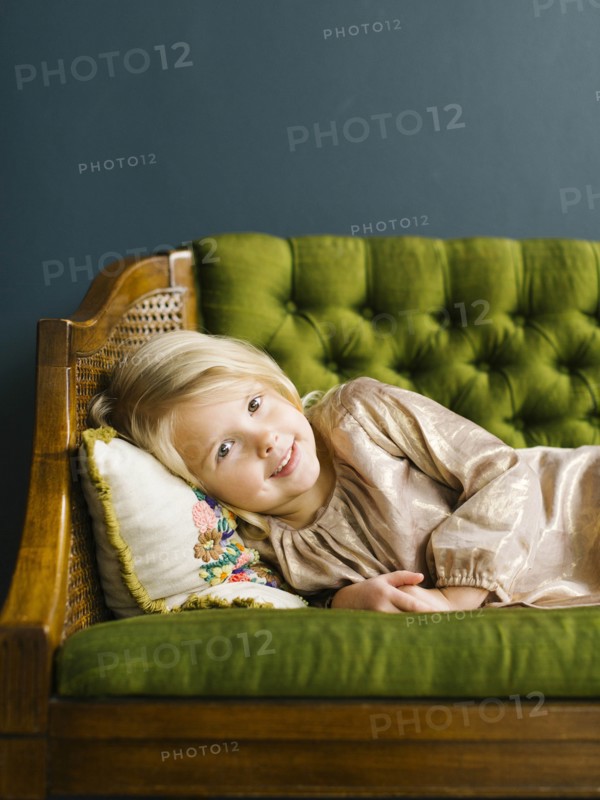 Girl  lying on green sofa