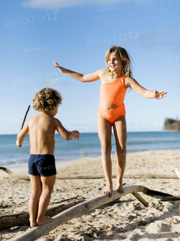 Children balancing on driftwood