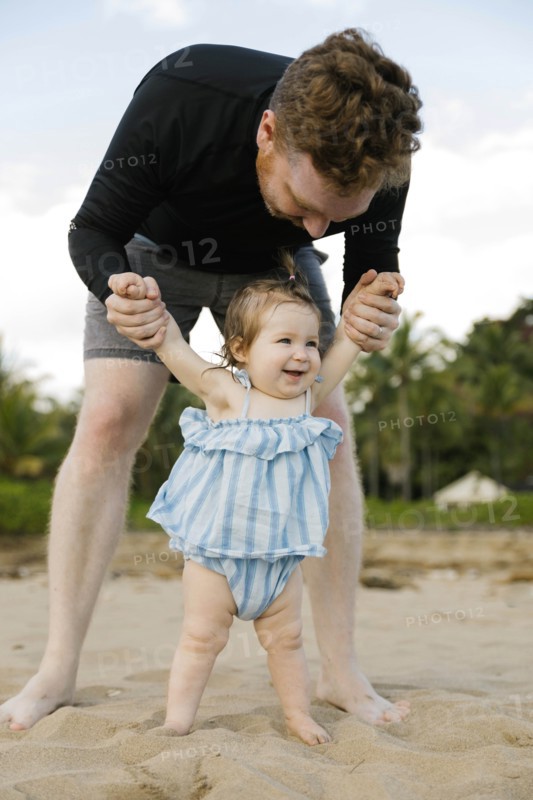 Man playing with baby daughter on beach
