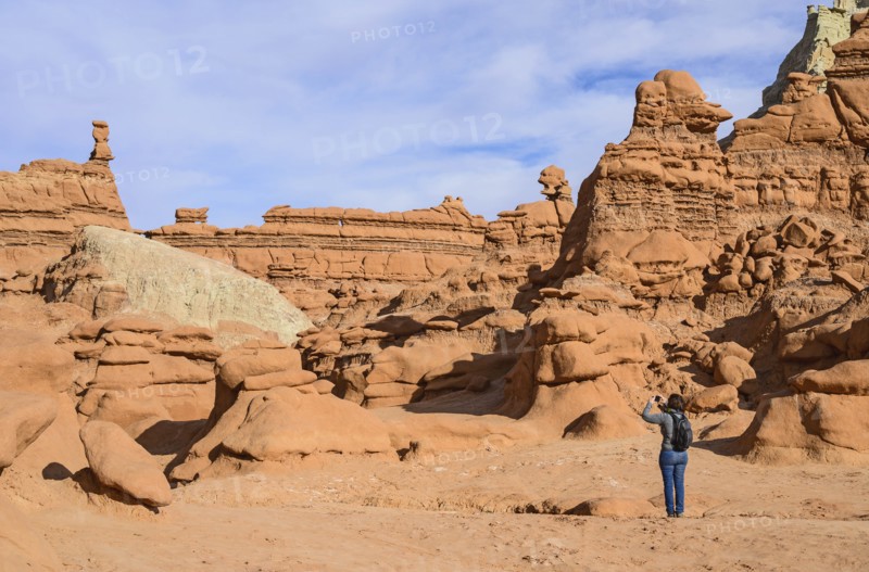 Woman photographing hoodoos in Goblin Valley State Park, Utah, USA