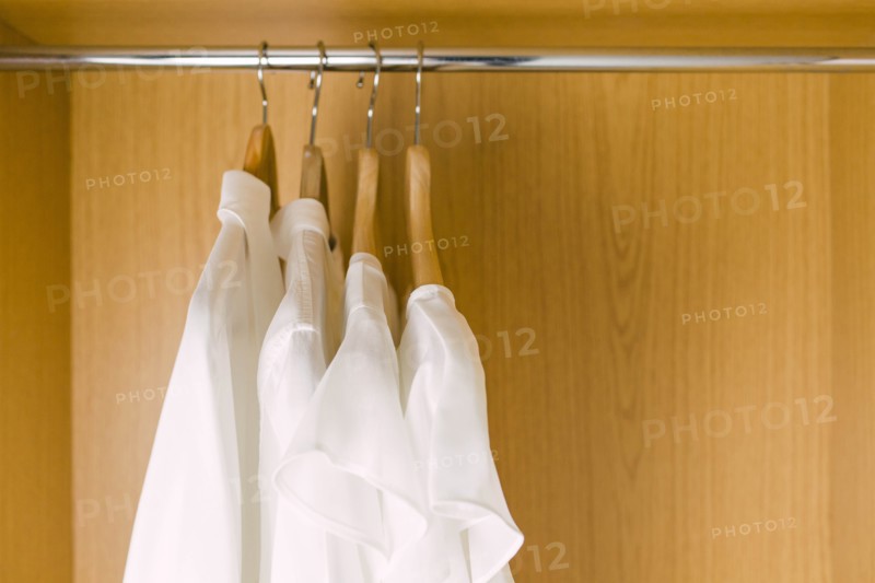Shirts on clothes hangers in wardrobe
