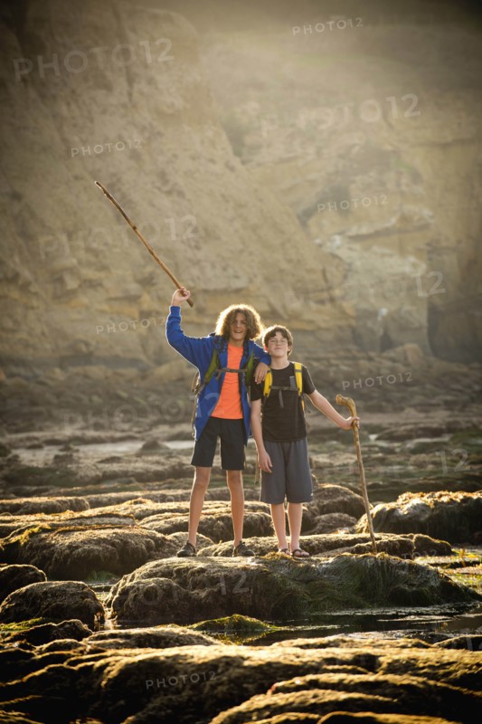 Teenage boys on rocks by tide pool in La Jolla, California