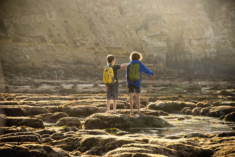 Teenage boys on rocks by tide pool in La Jolla, California