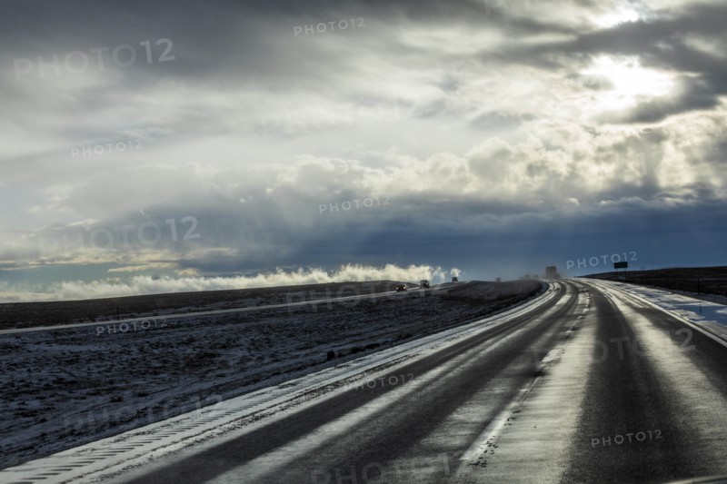Country road with snow under overcast sky