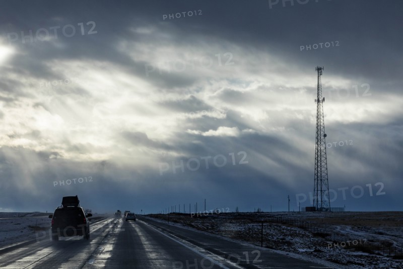 Country road with snow under overcast sky