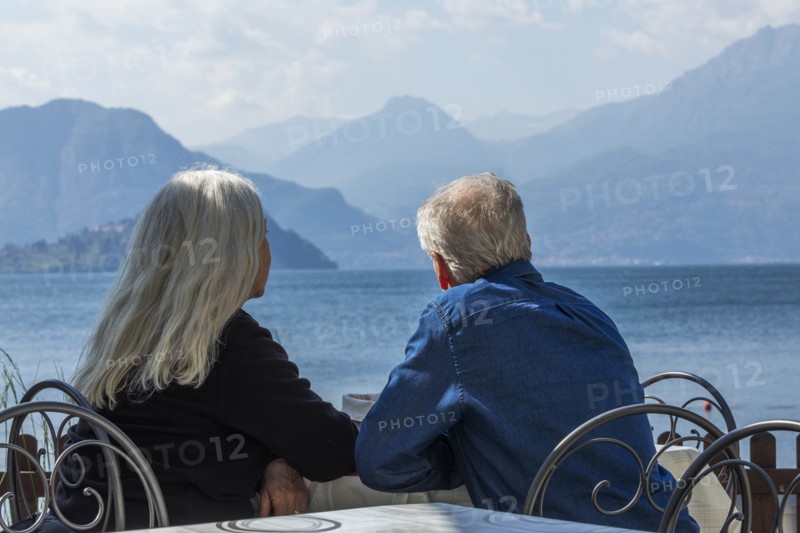Gray haired couple sitting by Lake Como in Lombardy, Italy