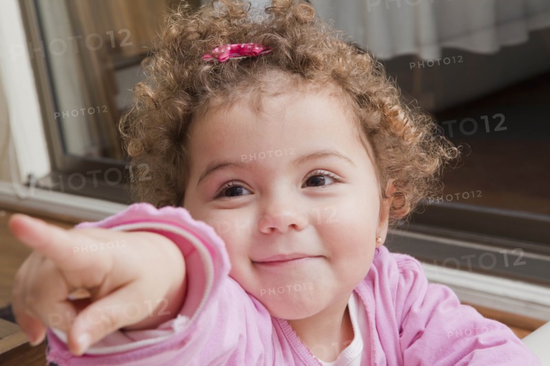 Girl with curly hair pointing