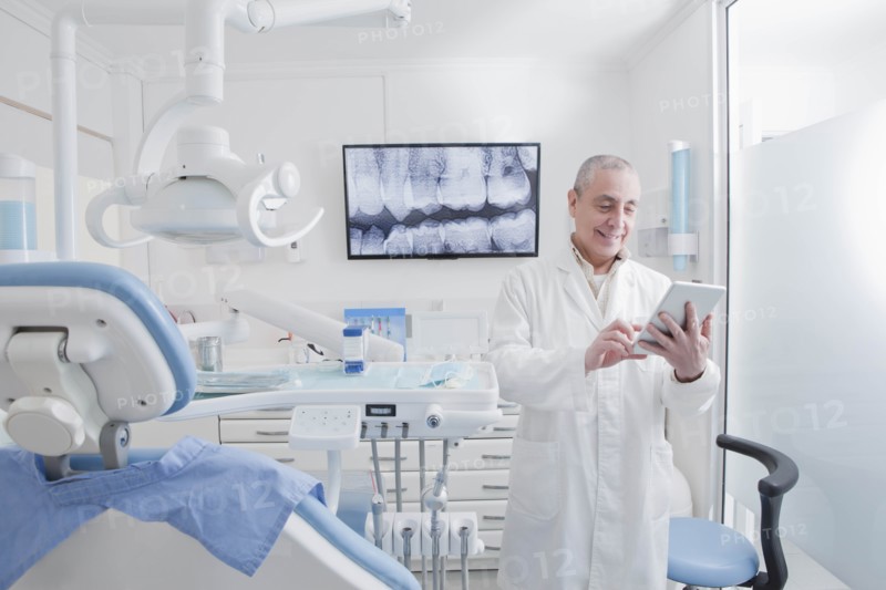 Dentist using digital tablet in dentist's surgery
