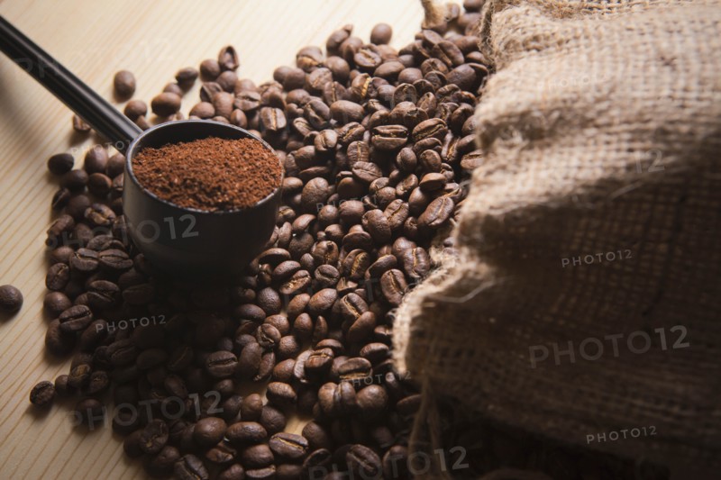 Portafilter holding ground coffee on roasted coffee beans