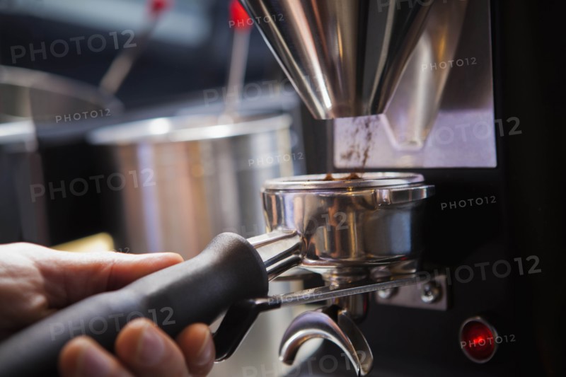 Barista collecting ground coffee in portafilter