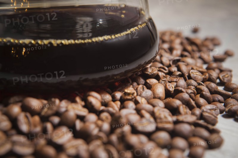 Jug of coffee on roasted coffee beans