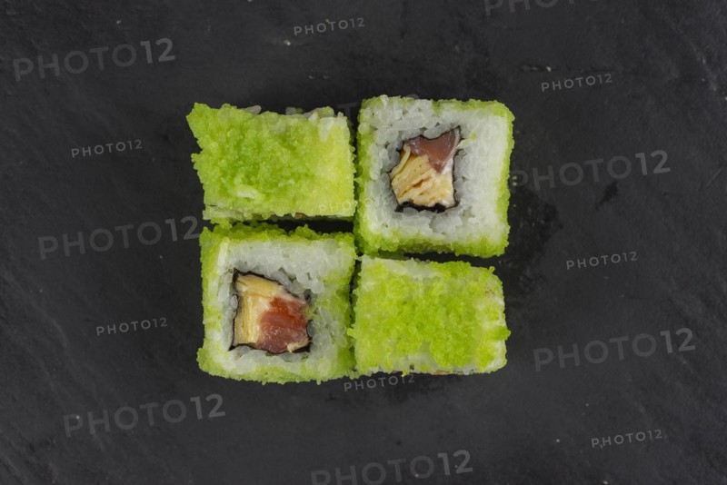 Green fish roe sushi on black surface