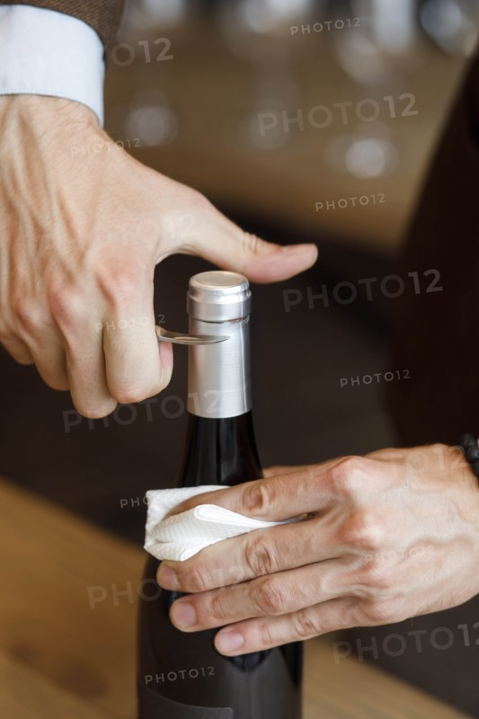 Hands of man opening bottle of wine
