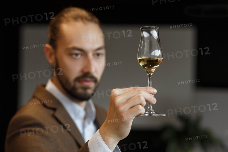 Young man examining glass of wine