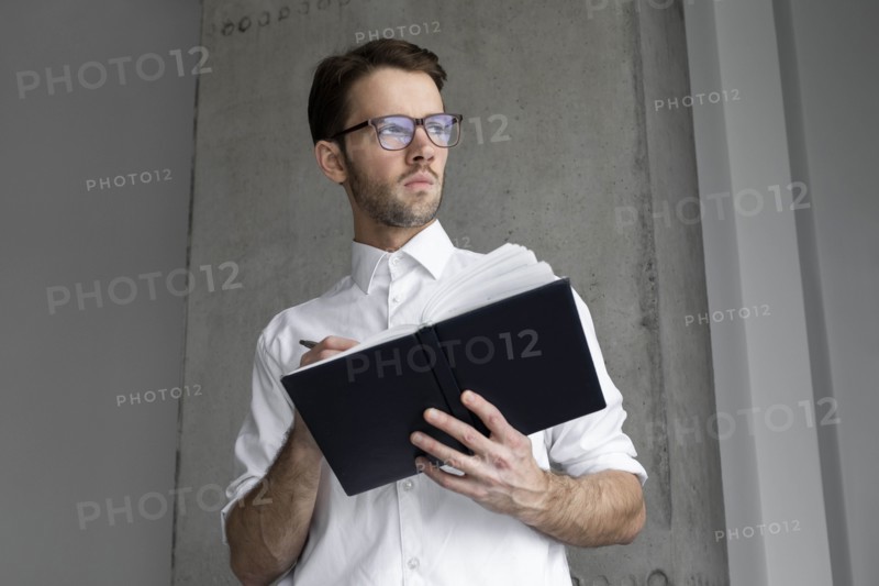 Businessman writing in note book